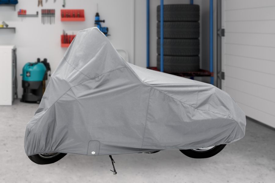 A covered motorcycle in the garage 